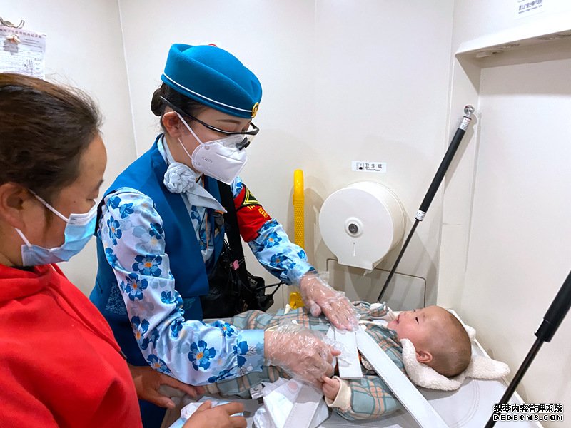 昆明客运段中老铁路列车长赵莹静帮助旅客为婴儿更换尿布。全国铁道团委供图