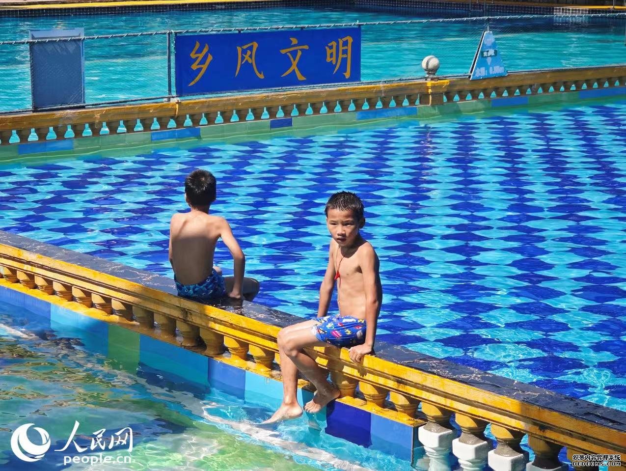 罗回村岜弄屯游泳池吸引力附近不少儿童前来游玩。 人民网 黄盛 摄