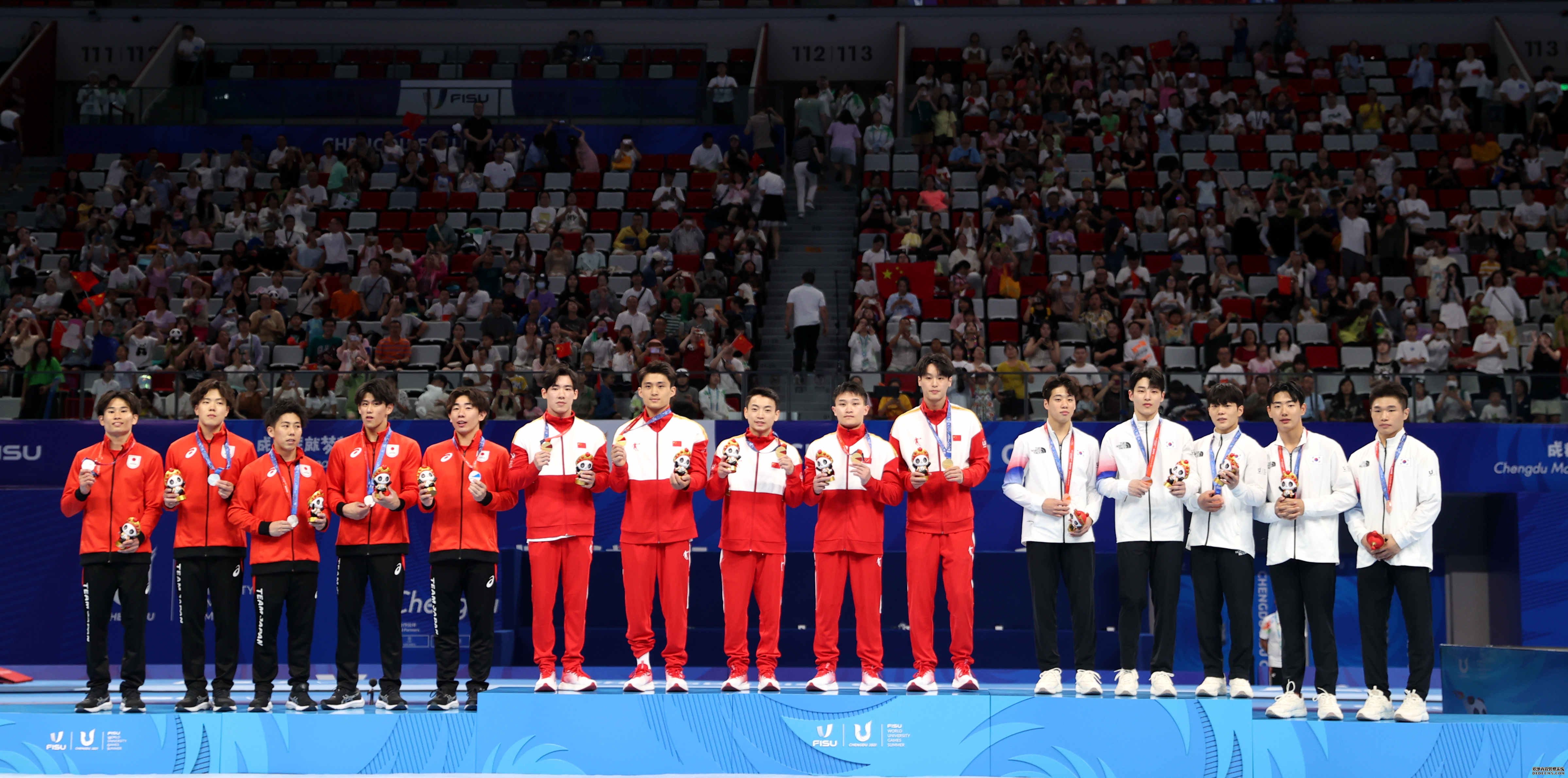 8月2日，冠军中国队（中）、亚军日本队（左）和季军韩国队在领奖台上合影。 当日，在成都举行的第31届世界大学生夏季运动会体操项目男子团体决赛中，中国队以262.594分的总成绩获得冠军。 新华社记者 张丽芸 摄