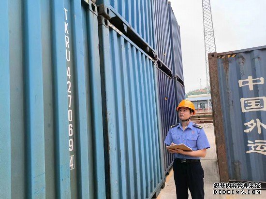 铁路货运员在检查集装箱箱体情况、记录箱号。中国铁路广州局集团有限公司供图