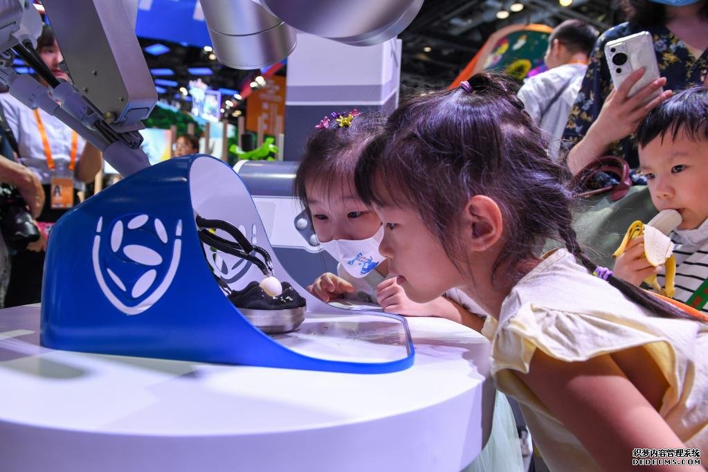 9月3日，几名小朋友在国家会议中心观看单孔腔镜手术机器人展示。新华社记者 鞠焕宗 摄