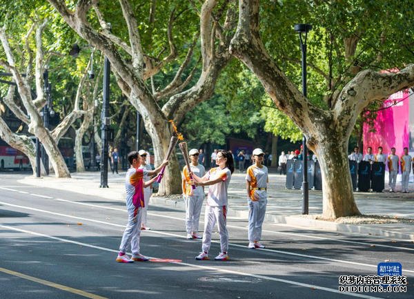 9月8日，杭州亚运会火炬传递在杭州西湖涌金公园广场启动，共有106棒火炬手参与当日传递。图为火炬手罗雪娟（右）和张勇在火炬传递中。 新华社记者 孙非 摄
