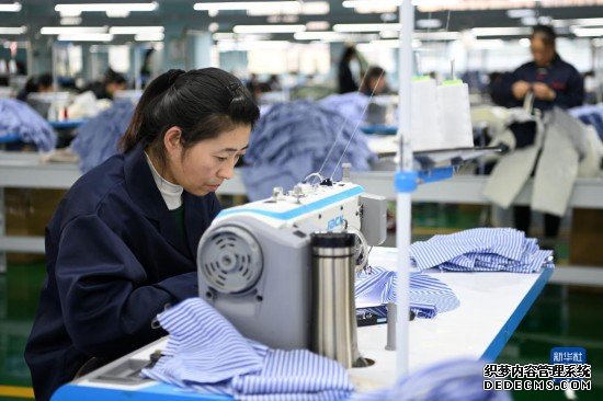 11月23日，工作人员在胶州·通渭服装产业园的一家服装企业生产车间工作。