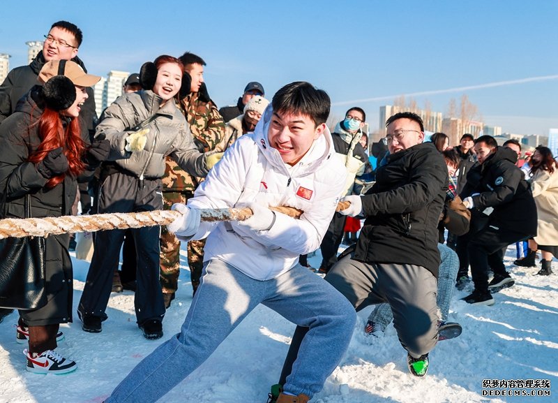 参赛选手在呼和浩特市干部职工冰雪趣味运动会上进行雪地拔河比赛。丁根厚摄