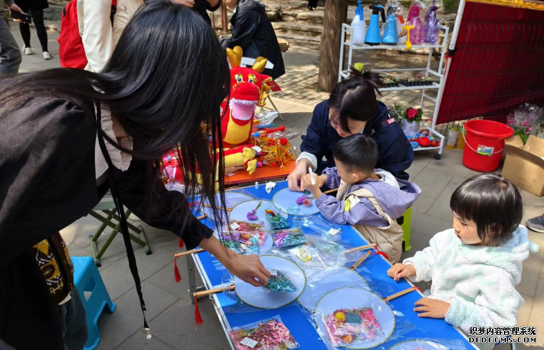 北京陶然亭公园开设的陶然市集上，小游客们正在体验画扇面。人民网记者 乔业琼摄