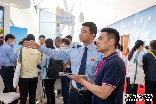 海口市税务局党委委员、总经济师李由向人民网记者介绍展台工作情况。人民网记者 翁奇羽摄