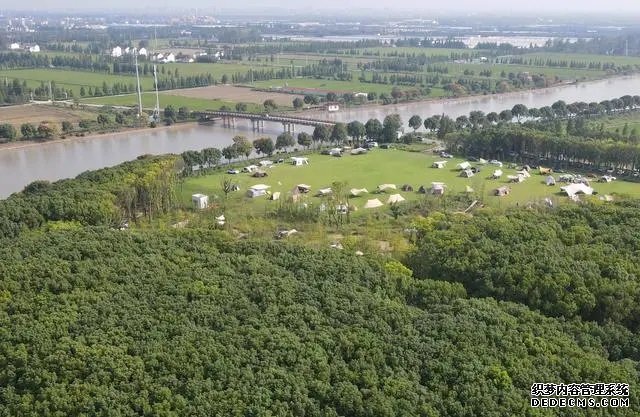 在上海松江区一处营地，市民游客在河边草地上搭起帐篷。（2023年9月29日，无人机照片）。新华社记者 方喆摄