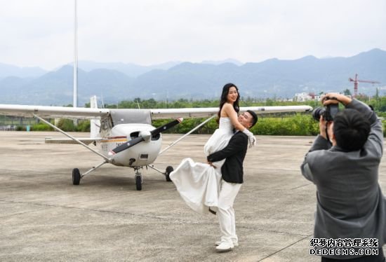 2024年5月3日，在重庆龙兴通用机场，一对即将乘坐轻型运动类飞机的新人在登机前合影。新华社记者 王全超 摄