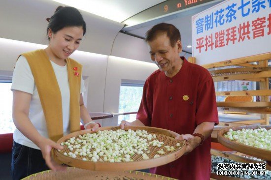 10月1日，福州市茉莉花茶窨制工艺代表性传承人张子建与旅客在G1634次列车上制作茉莉花茶。新华社记者周义 摄